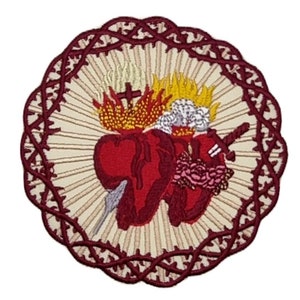 Könnte beinhalten: Gestickter Aufnäher mit einem roten Herzen, einer Dornenkrone und einem Kreuz. Das Herz ist von einem Flammenkreis und einem weißen Hintergrund umgeben. Der Aufnäher ist von einem kastanienbraunen Rand mit einem dekorativen Muster umrahmt.