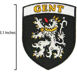 May include: Embroidered patch, 6.35 cm wide and 7.87 cm tall, featuring the word "GENT" in yellow letters above a white lion rampant with a yellow crown and accents, set against a black shield-shaped background.