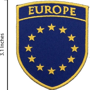 Pode incluir: Um patch bordado azul e amarelo, com cerca de 6,35 cm de largura e 7,87 cm de altura, com a palavra "EUROPE" no topo. Apresenta um círculo de estrelas amarelas sobre um fundo azul, representando a União Europeia.