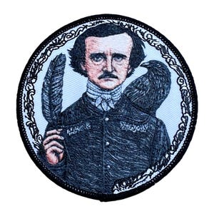 May include: Embroidered patch featuring a portrait of Edgar Allan Poe with a raven perched on his shoulder. The patch is circular and has a black border with a white and black ornate design.