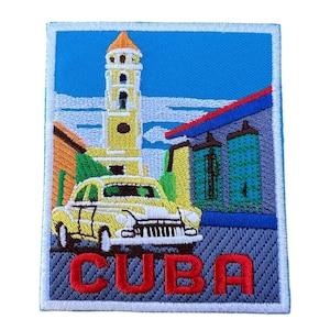 Peut inclure: Patch brodé représentant une voiture jaune roulant dans une rue d'une ville cubaine. La voiture est devant un grand bâtiment jaune avec une tour d'horloge. Le texte "CUBA" est en lettres rouges en bas du patch.