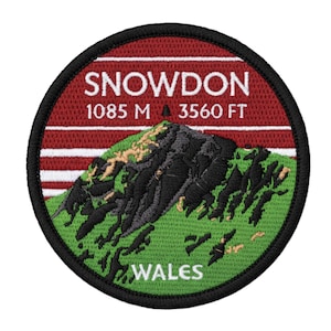 Può includere: Toppa ricamata circolare raffigurante il monte Snowdon in Galles. Il design include il testo "SNOWDON", l'altezza in metri e piedi e la parola "WALES". La toppa ha uno schema di colori rosso, verde e nero.