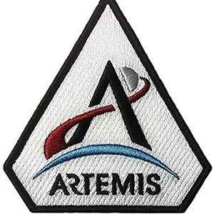 May include: A white triangular patch with a black outline and a stylized letter A with a red and blue orbit around it. The text "ARTEMIS" is printed in black at the bottom of the patch.