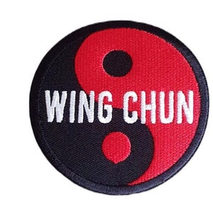 Könnte beinhalten: Schwarzer und roter gestickter Aufnäher mit einem Yin-Yang-Symbol und dem Text "WING CHUN" in Weiß.