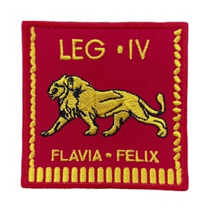 Op de afbeelding: Een rood geborduurd patch met een gouden leeuw en de tekst "LEG IV FLAVIA FELIX".