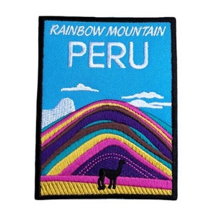 Może przedstawiać: Naszywka haftowana przedstawiająca kolorowy pasmo górskie z lamą na pierwszym planie. Naszywka ma niebieski tło z białymi chmurami i tekstem "RAINBOW MOUNTAIN PERU" u góry.