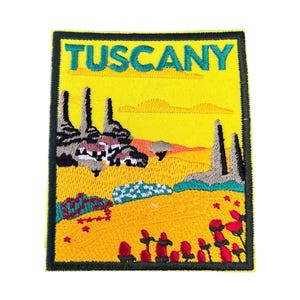 Könnte beinhalten: Gestickter Aufnäher mit gelbem Hintergrund und grünem Rand. Der Aufnäher zeigt eine stilisierte Landschaft mit einem weißen Haus, grünen Bäumen und roten Blumen. Der Text "TUSCANY" ist oben auf dem Aufnäher in grün gestickt.