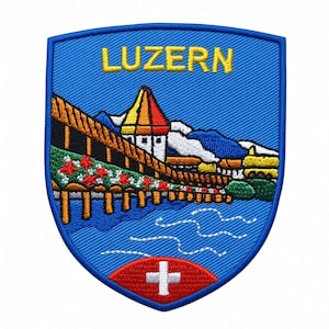 Puede incluir: Un parche bordado en forma de escudo con fondo azul y el texto LUZERN en amarillo. El diseño muestra un puente de madera con flores rojas, una torre con techo rojo y amarillo, montañas y un óvalo rojo con una cruz blanca.