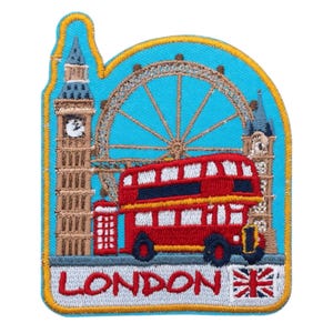 Może przedstawiać: Haftowana naszywka z charakterystycznymi zabytkami Londynu. Czerwony piętrowy autobus, Big Ben i London Eye na niebieskim tle. Słowo "LONDON" i flaga Union Jack na dole. Naszywka ma żółtą obwódkę.