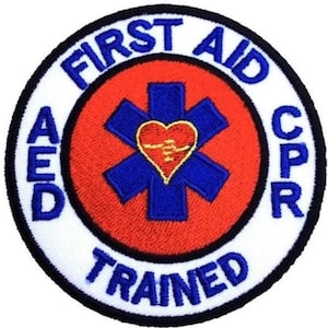 May include: A white and blue circular patch with the text "First Aid CPR AED Trained" around a red circle with a blue star of life and a red heart with a yellow lightning bolt inside.