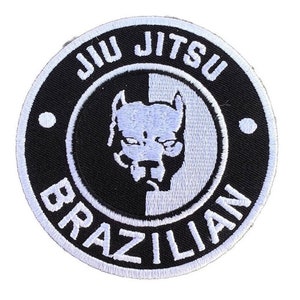 Può includere: Toppa ricamata in bianco e nero con una silhouette di pitbull bianca al centro. Il testo "Jiu Jitsu Brazilian" è ricamato in bianco attorno al bordo della toppa.