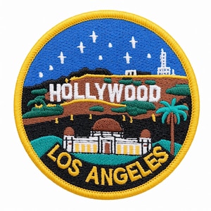 Könnte beinhalten: Ein runder gestickter Aufnäher mit einem blauen Nachthimmel mit weißen Sternen über einem braunen Hügel mit dem weißen Schriftzug HOLLYWOOD. Darunter befindet sich ein weißes Gebäude mit braunen Kuppeln über dem gelben Text LOS ANGELES.