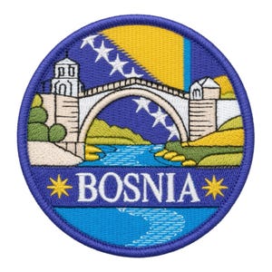 May include: A circular embroidered patch featuring a stone arch bridge over a blue river, set against a background of the Bosnian flag with yellow, blue, and white stars. The word BOSNIA is stitched in white capital letters between two yellow stars.