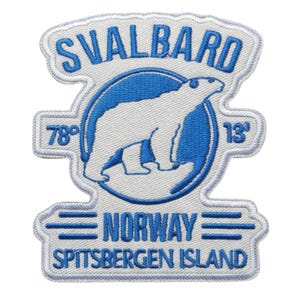 Op de afbeelding: Geborduurde patch met een ijsbeer in een blauwe cirkel, met de tekst "SVALBARD" erboven en "NORWAY SPITSBERGEN ISLAND" eronder. De patch heeft een witte achtergrond met blauwe en witte stiksels.