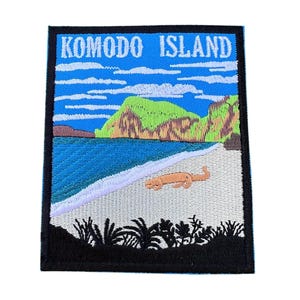 Könnte beinhalten: Gestickter Aufnäher mit einem farbenfrohen Bild von Komodo Island, das einen Strand, das Meer und eine Eidechse zeigt. Der Text "Komodo Island" ist in Weiß auf schwarzem Hintergrund gestickt.