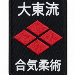 Peut inclure: Un écusson rectangulaire brodé noir avec des caractères kanji japonais blancs en haut et en bas. Au centre, un emblème en forme de losange rouge est composé de quatre segments en losange plus petits disposés en un motif de losange.