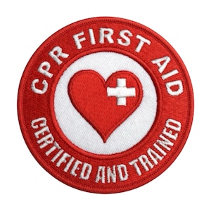 May include: A circular red and white embroidered patch with the words "CPR FIRST AID CERTIFIED AND TRAINED" in white. The center features a red heart with a white cross.