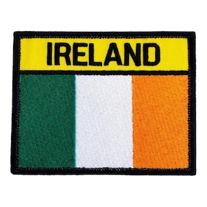 Może przedstawiać: Haftowana naszywka z flagą Irlandii. Prostokątna naszywka ma żółtą górną część z napisem "IRELAND" czarnymi, dużymi literami. Poniżej flaga przedstawia pionowe pasy w kolorze zielonym, białym i pomarańczowym, z czarną obwódką.