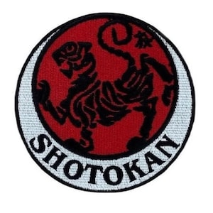 Op de afbeelding: Een geborduurde patch met een zwart tijgersilhouet op een rode achtergrond, omringd door een witte cirkel met het woord "SHOTOKAN" in witte letters.