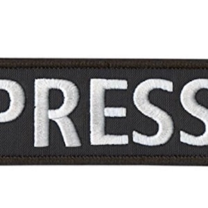 Peut inclure: Écusson rectangulaire noir avec du texte brodé en blanc qui dit "PRESS".