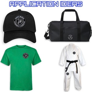 K&ouml;nnte beinhalten: Eine schwarze Reisetasche mit einem wei&szlig;en Logo, auf dem "KRAV MAGA CONTACT COMBAT" steht. Es gibt auch eine schwarze Baseballkappe mit dem gleichen Logo, ein gr&uuml;nes T-Shirt mit dem gleichen Logo und einen wei&szlig;en Karateanzug mit einem schwarzen G&uuml;rtel und dem gleichen Logo.