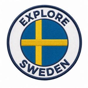 May include: A circular embroidered patch featuring the flag of Sweden in the center with a blue background and a yellow cross. The white border contains the dark blue text EXPLORE at the top and SWEDEN at the bottom, finished with a dark blue edge.