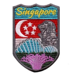 Könnte beinhalten: Gestickter Aufnäher mit der Flagge Singapurs mit einem Halbmond und fünf Sternen, einer Löwenstatue, einer Bergkette und einer rosa Blume. Der Aufnäher ist grau mit einem blauen, weißen, roten und grünen Hintergrund. Der Text "Singapur" ist in Gelb gestickt.