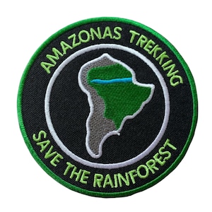 May include: Embroidered patch with a black background, featuring a green and gray map of South America. The patch has a white border and green text that reads "AMAZONAS TREKKING" and "SAVE THE RAINFOREST". A blue line represents a river.