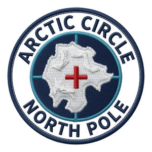 Op de afbeelding: Een ronde geborduurde patch met een donkerblauw midden, een witte kaartomtrek en een rood kruis. De witte rand bevat de tekst ARCTIC CIRCLE bovenaan en NORTH POLE onderaan in donkerblauwe letters, met een lichtblauw vizierkruis.