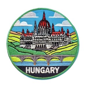 May include: Embroidered patch featuring the Hungarian Parliament Building. The patch is circular with a blue sky background, green hills, and a bridge over water. The word "HUNGARY" is at the bottom.