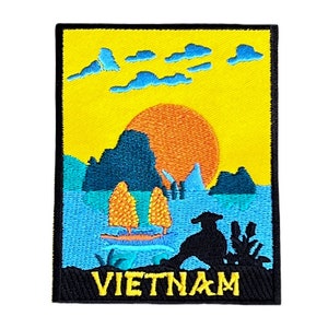Peut inclure: Patch brodé avec un fond jaune représentant un coucher de soleil sur une chaîne de montagnes avec un bateau dans l'eau. Le texte "VIETNAM" est en bas du patch.