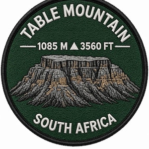 Op de afbeelding: Een ronde geborduurde patch met een donkergroene achtergrond en een gedetailleerde afbeelding van de Tafelberg in grijze en bruine tinten. De witte tekst luidt TABLE MOUNTAIN, 1085 M, 3560 FT en SOUTH AFRICA.