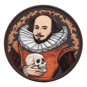Puede incluir: Un parche bordado circular que presenta un retrato de William Shakespeare con un cuello de lechuguilla blanco y un jubón color óxido. Sostiene un cráneo humano en su mano. El diseño está enmarcado por un borde de color dorado ornamentado.