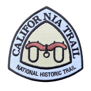 May include: A blue and white embroidered patch with the text "California Trail National Historic Trail" and a stylized image of a yoke and oxbow.