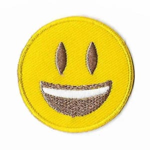Könnte beinhalten: Gelber gestickter Smiley-Patch mit weißem Lächeln und braunen Augen.