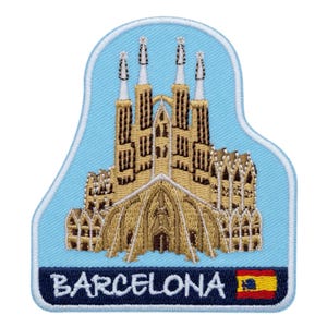 Könnte beinhalten: Gestickter Aufnäher mit der Sagrada Família Basilika in Barcelona, Spanien. Der Aufnäher hat einen hellblauen Hintergrund und einen dunkelblauen Rand. Das Wort "BARCELONA" ist unten gestickt, mit der spanischen Flagge.
