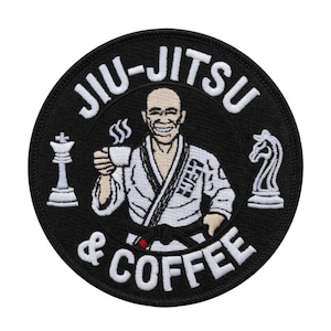 Puede incluir: Parche circular negro con texto blanco "JIU-JITSU & COFFEE". El parche presenta una figura de dibujos animados sonriente con un gi blanco sosteniendo una taza de café, con piezas de ajedrez a cada lado.