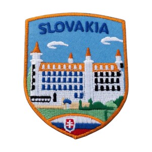 Op de afbeelding: Geborduurde patch met een afbeelding van een kasteel met het woord "SLOVAKIA" in blauwe letters tegen een lichtblauwe lucht. De patch heeft een oranje rand en een schildvorm, met het Slowaakse wapen onderaan.