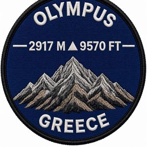 May include: A circular embroidered patch with a dark blue background featuring a mountain range in shades of gray and brown. The text OLYMPUS is at the top, GREECE is at the bottom, and 2917 M 9570 FT is in the center, all in white stitching.