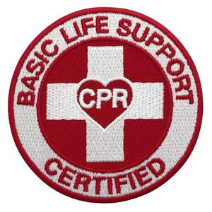 May include: A circular red and white embroidered patch with the words "BASIC LIFE SUPPORT CERTIFIED" around the edge. A white cross is centered, with a red heart containing "CPR" in the middle.