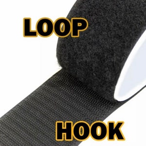 Pode incluir: Um rolo de fita de velcro preta. A fita est&aacute; etiquetada como "HOOK" e "LOOP" na imagem.