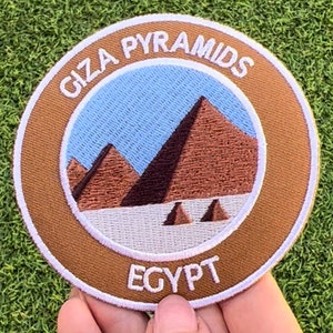 Op de afbeelding: Een bruin en wit geborduurde patch met de tekst "Giza Pyramids Egypt". De patch toont een blauwe lucht en drie bruine piramides.
