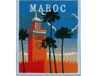 May include: Embroidered patch featuring a Moroccan scene with a tall, orange tower, palm trees, and the word "MAROC" in white letters against a blue sky. The patch has a light blue border and depicts a beach scene.