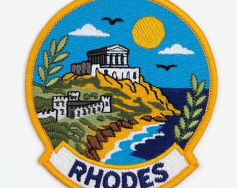 Pode incluir: Patch bordado com uma paisagem de Rodes, Grécia. O design inclui um templo branco, uma costa com praia e a palavra "RHODES" numa faixa. O patch tem uma borda amarela e um céu azul.