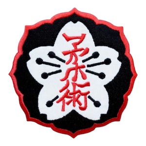 May include: Embroidered patch featuring a white flower design with black and red accents. The flower shape contains Japanese characters in red. The patch has a black border with a red scalloped edge.
