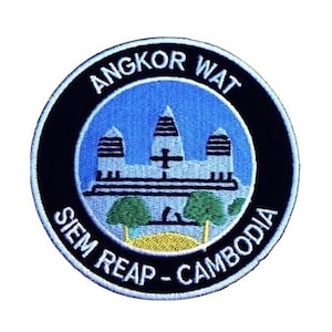 May include: A round, black and white embroidered patch with the text "Angkor Wat Siem Reap - Cambodia" and a depiction of the Angkor Wat temple in blue, white, and green.