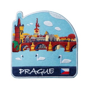May include: Embroidered patch featuring a colorful depiction of Prague's cityscape, including a bridge, buildings, and swans against a light blue sky. The word "PRAGUE" is embroidered in white, with the Czech flag.