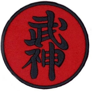 May include: A red circle with a black Japanese kanji symbol for "Bushido" in the centre. The kanji is stylised and has a traditional look.