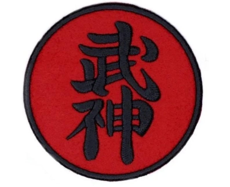 May include: A red circle with a black Japanese kanji symbol for "Bushido" in the centre. The kanji is stylised and has a traditional look.