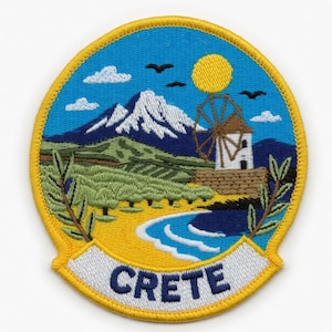Puede incluir: Parche bordado con un paisaje de Creta. El diseño incluye un molino de viento, montañas, una playa y la palabra "CRETE" en una pancarta. El parche tiene un borde amarillo y un fondo de cielo azul.